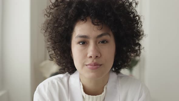 POV Young Curly Female Doctor Smiling at Camera