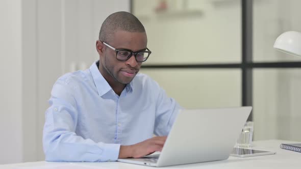 African Man with Laptop Shaking Head As Yes Gesture