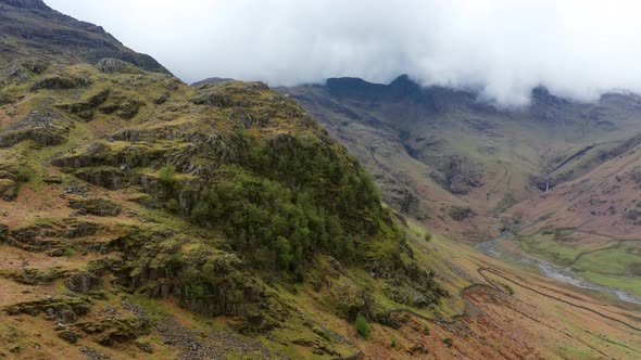 Aerial View Over Hills Towards Mountains