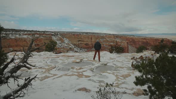 Man Celebrating after making it to the top of a mountain in the snow