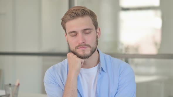 Portrait of Young Creative Man Taking Nap in Office