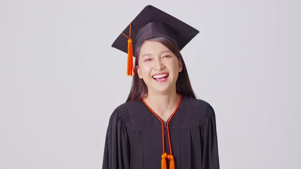 Beautiful Attractive Asian woman graduated in cap and gown smile