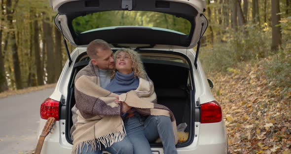 Happy Couple Sitting in a Car in the Autumn Park