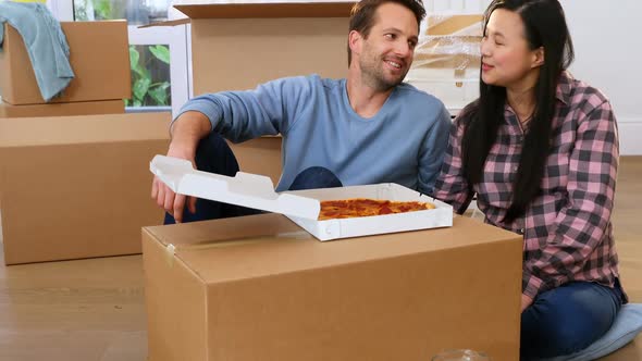 Couple having pizza in new house 4k