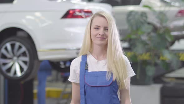 Cheerful Caucasian Woman Standing at the Background of Car and Showing Car Keys To Camera. Blond