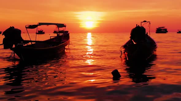 Aerial shot of Koh Tao island, Super sunset at Sairee Beach with many boats floating Thailand