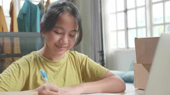 Close Up Of Asian Young Girl Online Seller With Package Writing While Selling Clothes At Home