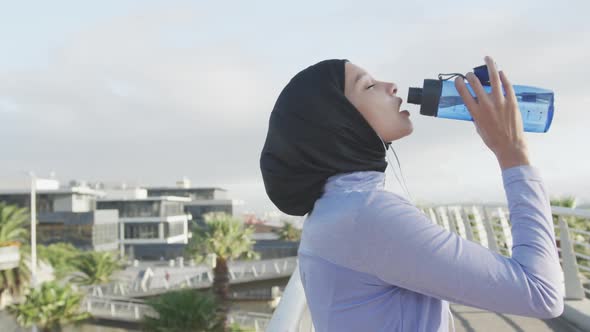 Side view of woman wearing hijab drinking outside
