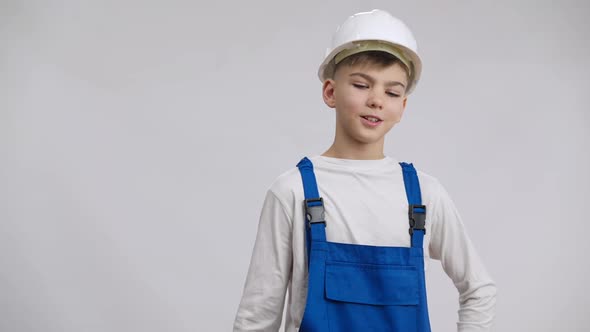 Positive Confident Boy Hanging Builder Uniform on Shoulder Sighing Smiling Looking at Camera