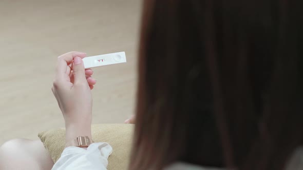 Over The Shoulder Shot Of Woman Holding Pregnancy Test, New Life And New Family Concept