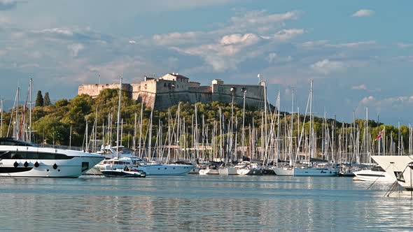 View of the sea port in Antibes, France. Moored boats and yachts, Fort Carre on the background, gree