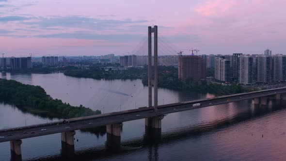 Aerial View of City Traffic Over River Bridge at Sundown