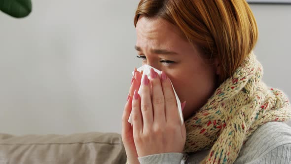 Sick Woman Blowing Nose in Paper Tissue at Home