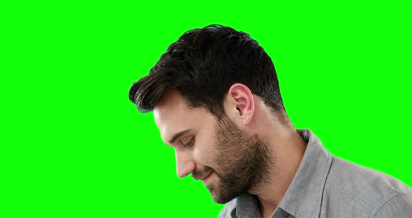 Thoughtful man standing against green background