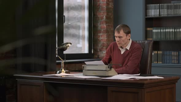 Man Working at His Desk with Vintage Typewriter