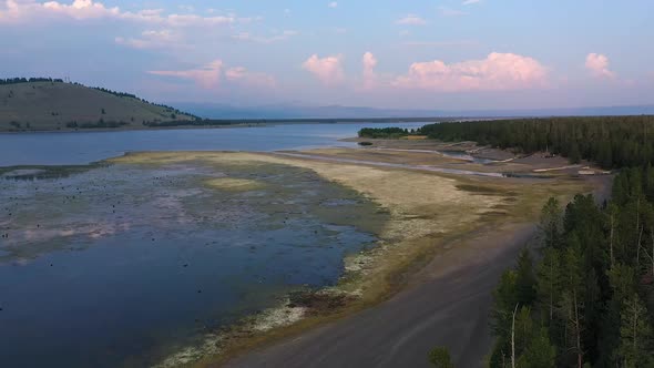 Aerial view over lake with low water looking along the shoreline at sunset