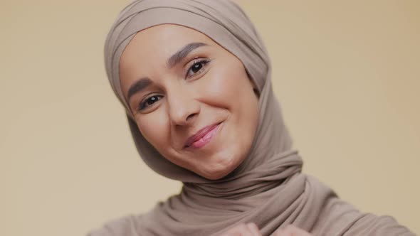 Close Up Portrait of Young Happy Muslim Lady in Traditional Headscarf Smiling Widely to Camera