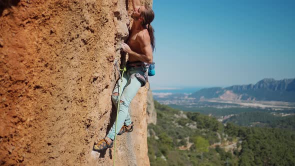 Slow Motion of Strong Man Rock Climber Climbs on Vertical Crag By Challenging Route