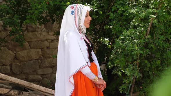 Young Woman Dressed In Traditional Dress Talking With Friend In The Village