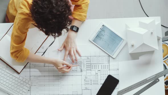 Top View of Cheerful Female Architect Drawing Floor Plan and Smiling