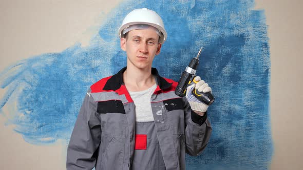 Worker Switches on Cordless Drill and Shows Approval Gesture