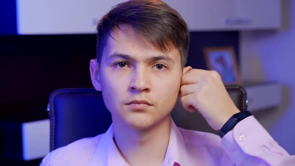 A Young Man Puts on a Digital Hearing Aid