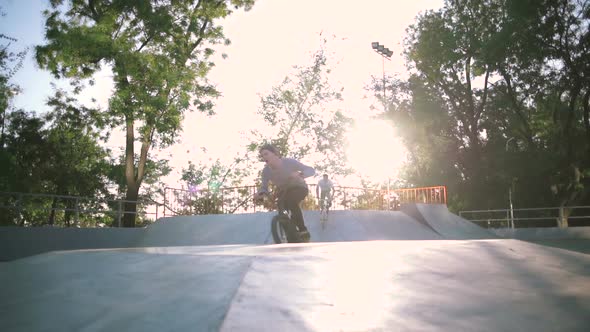 BMX Riders Doing Tricks in Extreme Park During Sunset Slow Motion