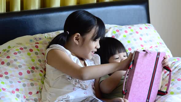 Cute Asian Child Playing Tablet On Bed