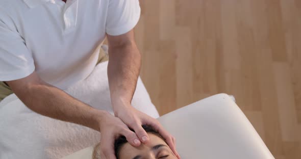 Female patient receiving head massage from physiotherapist