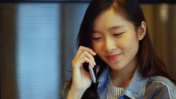 Businesswoman talking on the phone inside a meeting room at office.