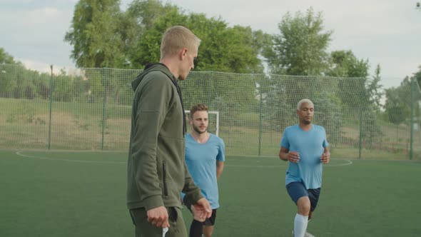 Coach Controlling Performing of Stretching Exercise By Team Outdoors