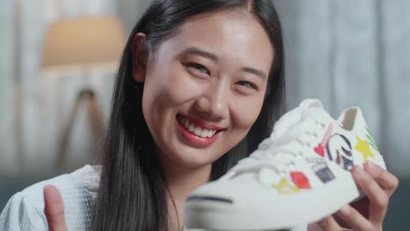 Close Up Of Smiling Asian Female Footwear Designer And Showing Thumbs Up Gesture To The Camera