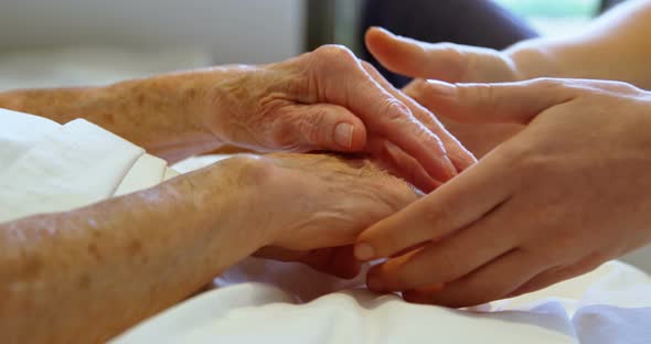 Hand of Doctor Reassuring to Senior Woman at Home 4k