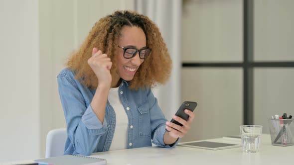 Successful African Woman Celebrating on Smartphone