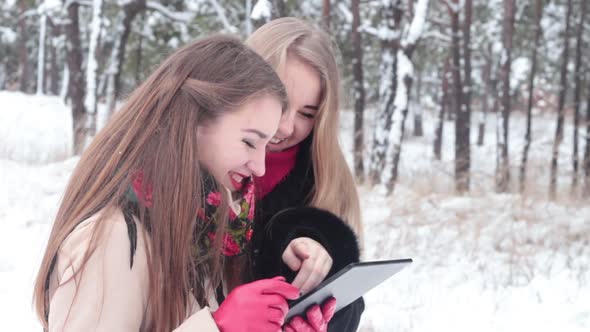 Girls In Winter Using Tablet