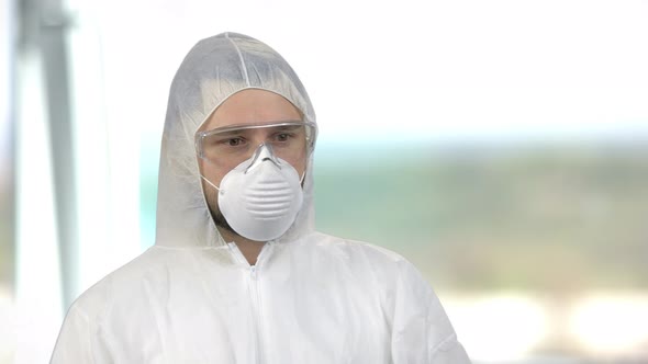 Portrait of a Man Wearing White Protective Clothing with Mask and Glasses