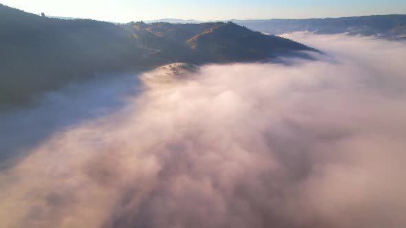 4K Scenic flight over beautiful mountain scape with bright sky and clouds