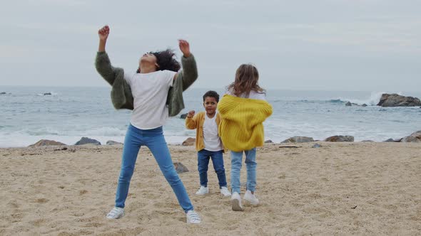 Small Funny Children Are Dancing On Beach