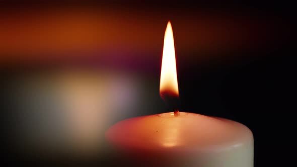 The showcases of colorful single candlelight on black background with the effect of light and slow m