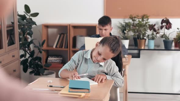 Schoolgirl Showing Drawing in Classroom