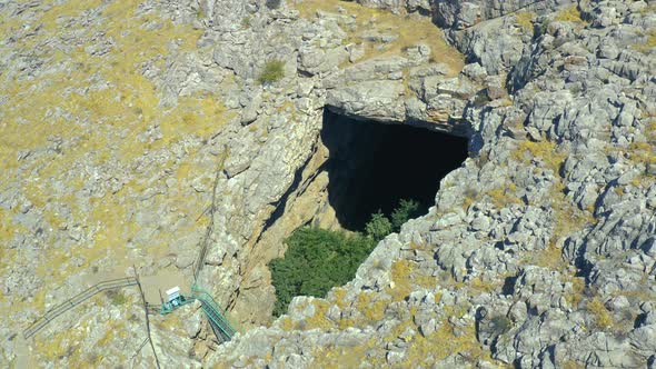 Big Hole Ak Mechet Cave with Trees Inside in Kazakhstan Mountain