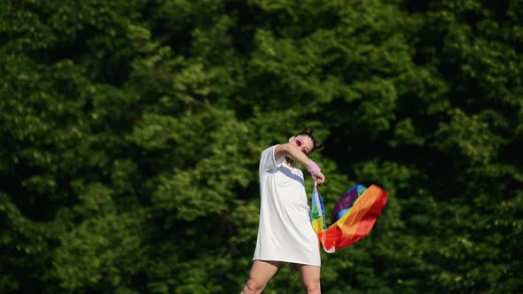 Young Woman Waving LGBT Pride Flag in the Park