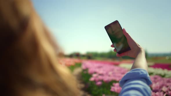 Back View of Young Woman Making Selfie at Cellphone