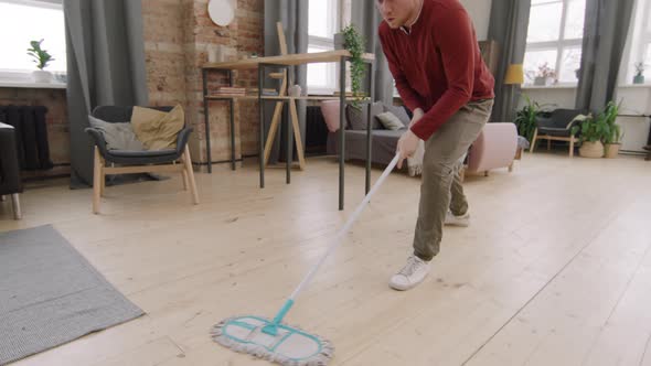 Carefree Man Mopping Floor and Dancing