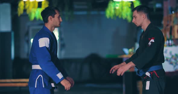 Young Guys Judokas Approach Each Other and Start a Fight. Training Fight of Judotists in the Gym.