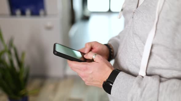 Man typing text, using online mobile application indoors, male enjoying communication