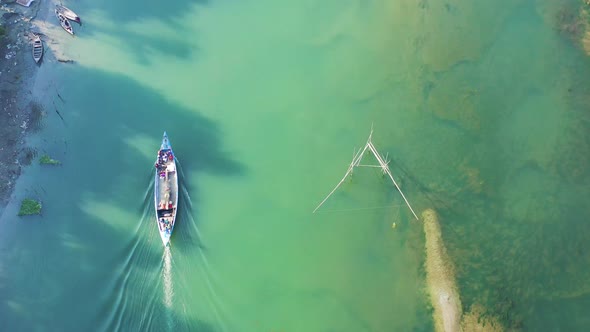 Aerial view of a fishing boat sailing the Kaliganga river in Dhaka, Bangladesh.