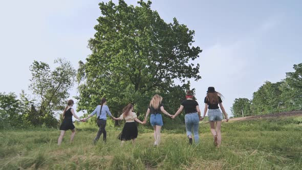 A Group of Girls are Walking Hand in Hand Outside the City