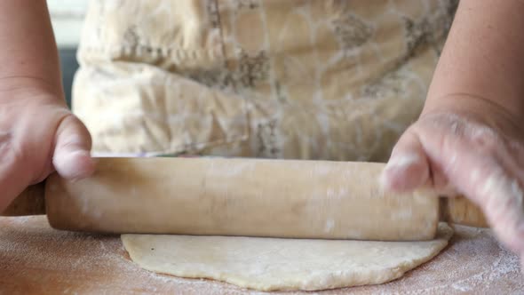 Woman Rolls Out the Dough with a Rolling Pin