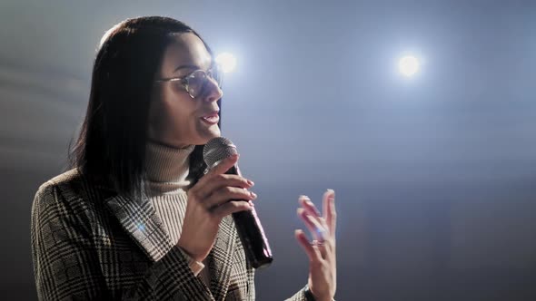 The Female Financial Coach Emotional Gesturing Talks From the Stage with Spectators at Forum